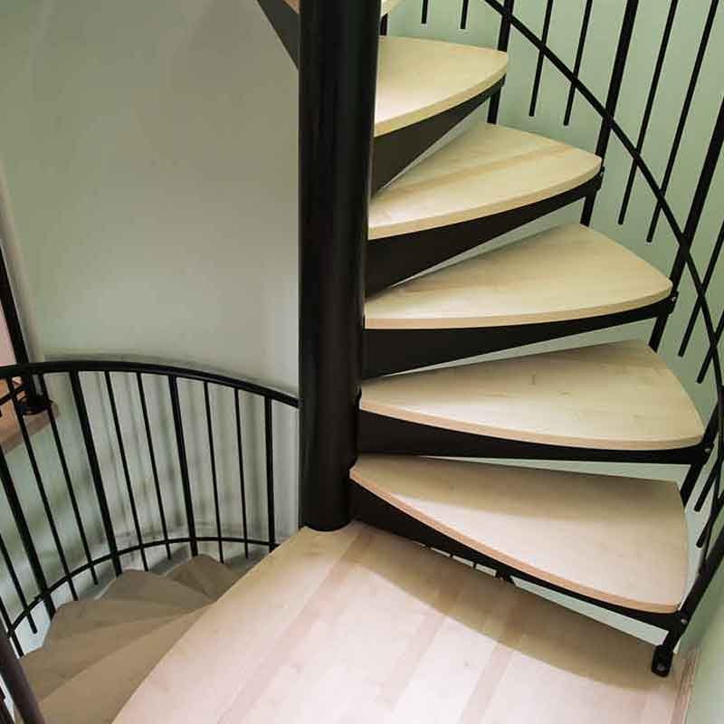 Light-wood-steps-on-a-spiral-staircase-with-blacksteel-column