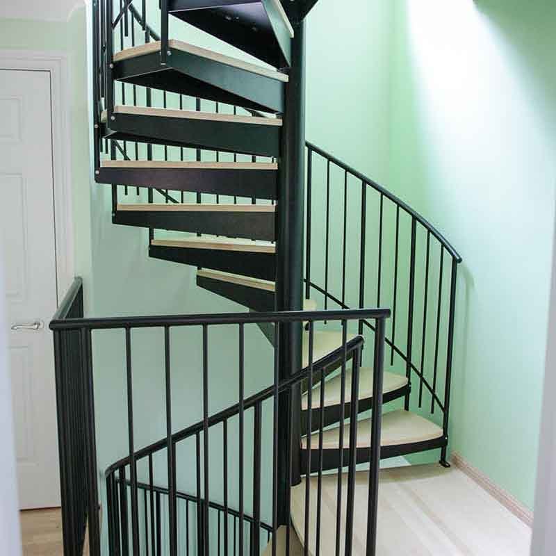 Mint-coloured-wall-with-black-spiral-staircase-with-platform