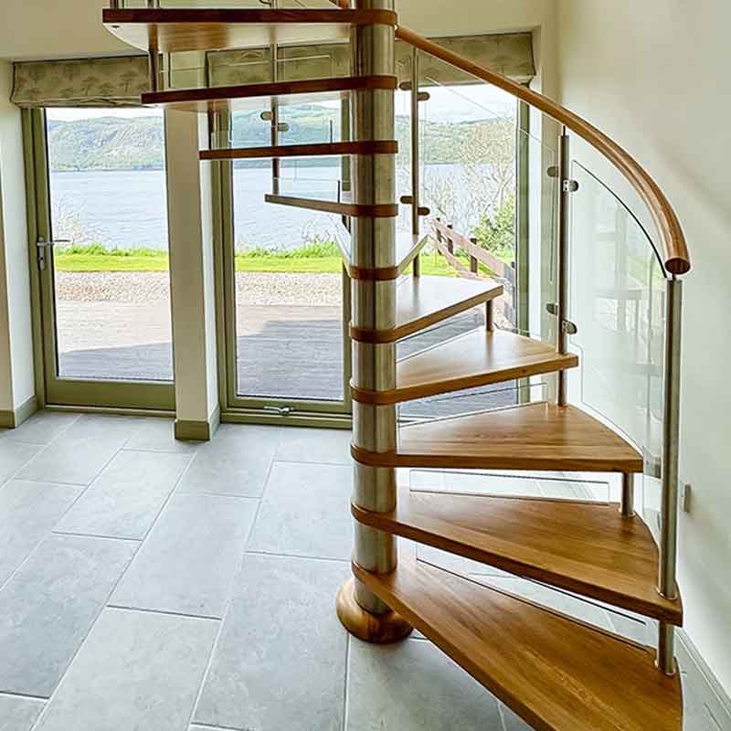 large window with lake beyond with spiral stair in foreground