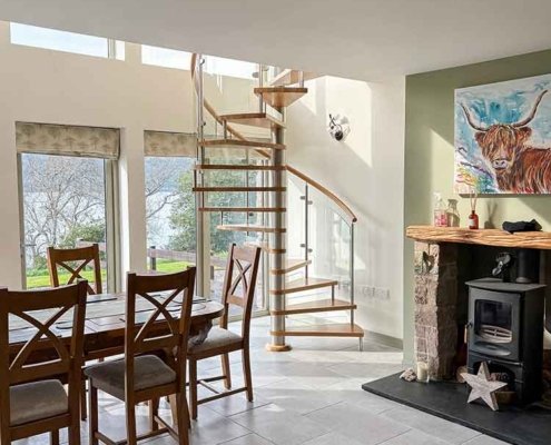 living area with nice spiral staircase in front of high windows