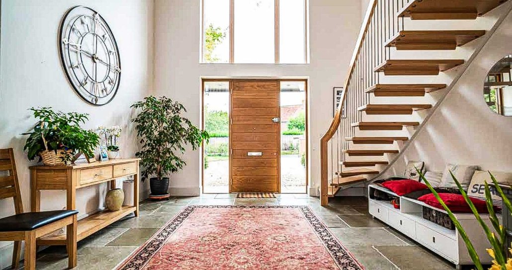 Large-hallway-with-oak-front-door-and-floating-staircase-to-one-side