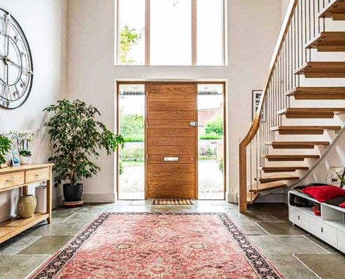 Large-hallway-with-oak-front-door-and-floating-staircase-to-one-side