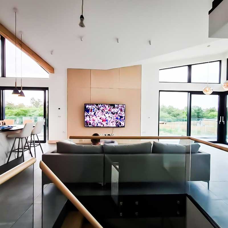 Frameless-glass-balustrade-around-a-stairwell-in-a-large-living-area