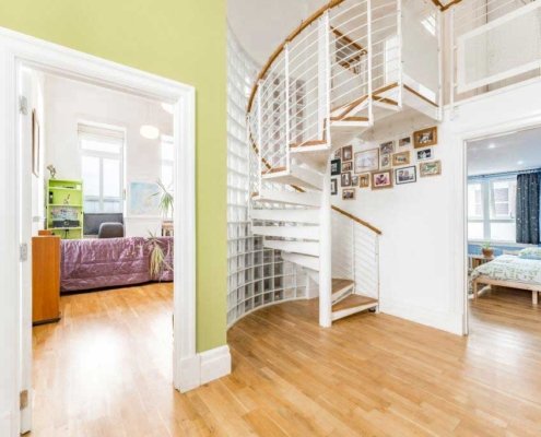 Hallway-in-Penthouse-with-white-spiral-stair-and-oak-flooring