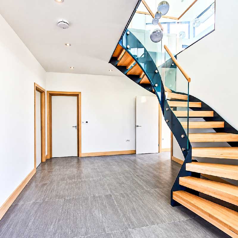 Modern-steel-and-glass-stair-rising-from-a-grey-hallway